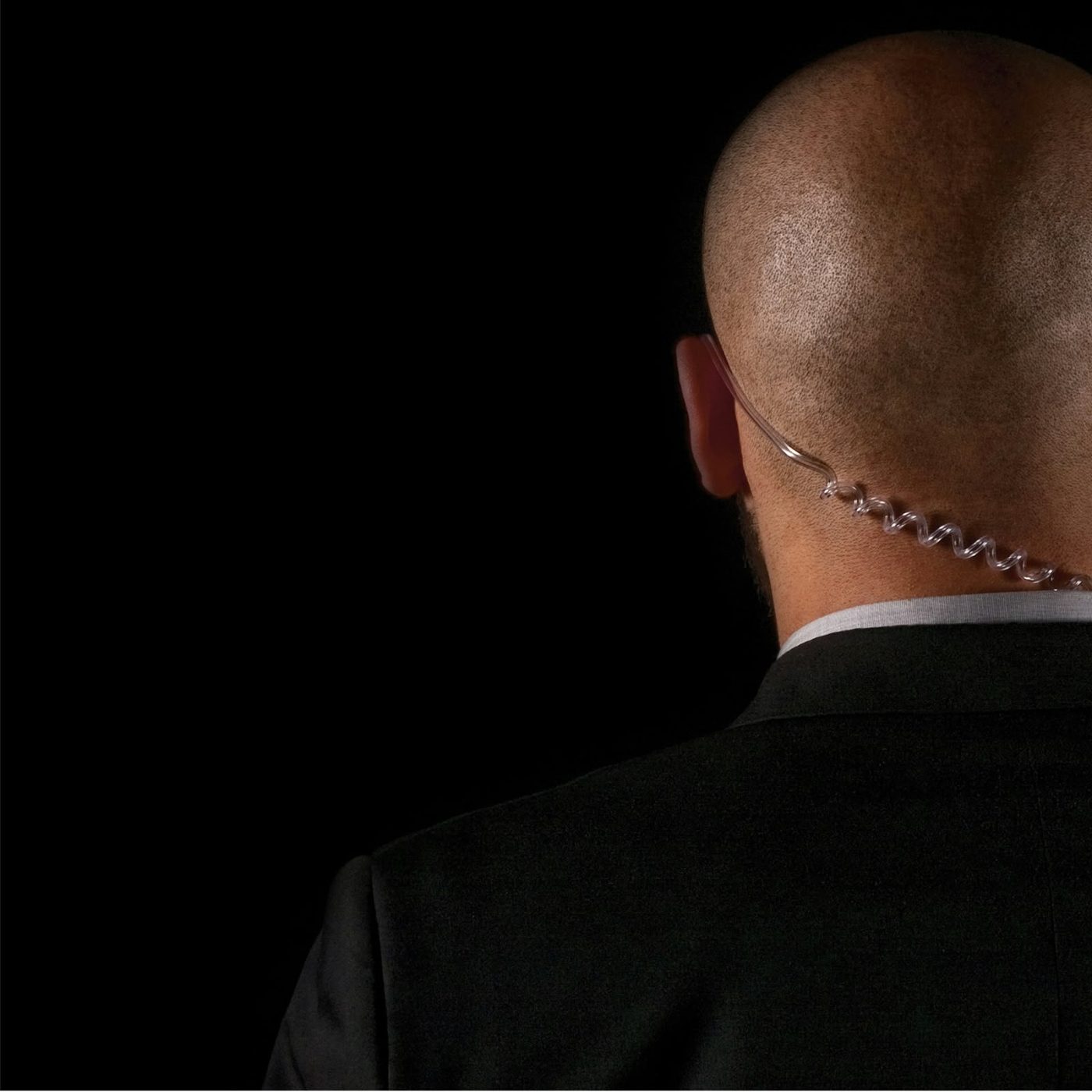 COPERSEC close protection agent in a black suit with a security earpiece