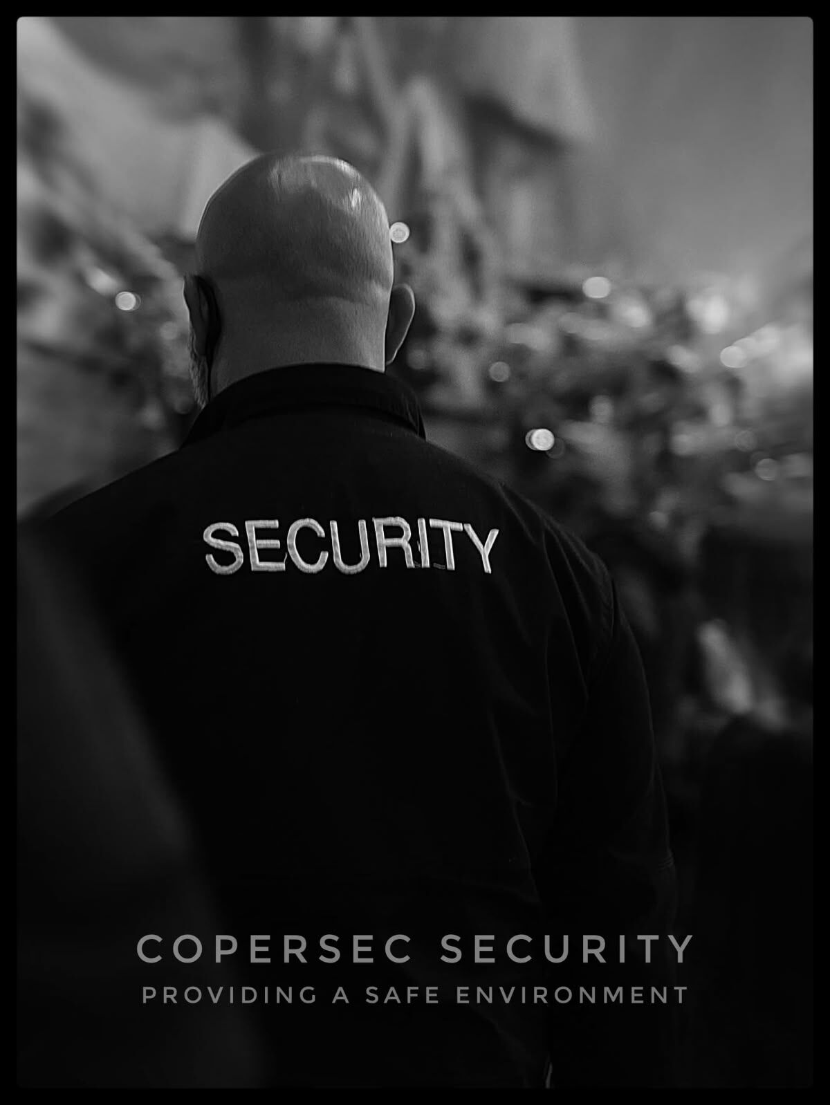 Agent in a black SECURITY jacket at a night event