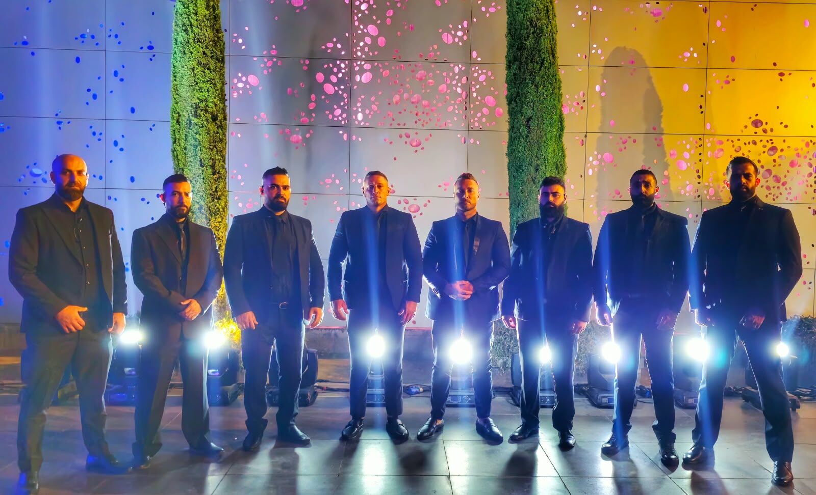 Eight COPERSEC close protection agents in black suits standing in a line